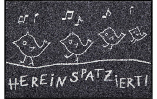 Fußmatte „Hereinspatziert“ mit weißen Vogelzeichnungen und Schriftzug auf dunklem Grund